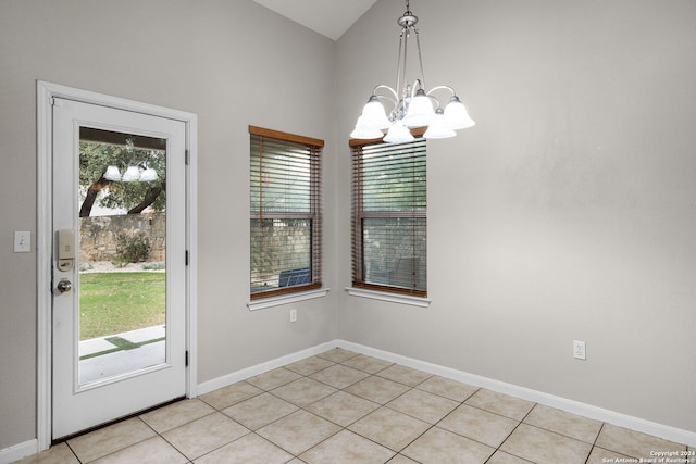 interior space featuring lofted ceiling, light tile patterned floors, and a notable chandelier