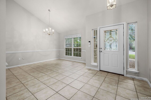 foyer featuring light tile patterned floors, lofted ceiling, and a notable chandelier