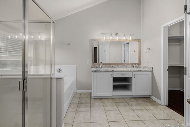 bathroom featuring lofted ceiling, vanity, tile patterned flooring, and shower with separate bathtub