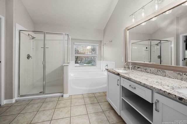 bathroom featuring separate shower and tub, vanity, vaulted ceiling, and tile patterned flooring