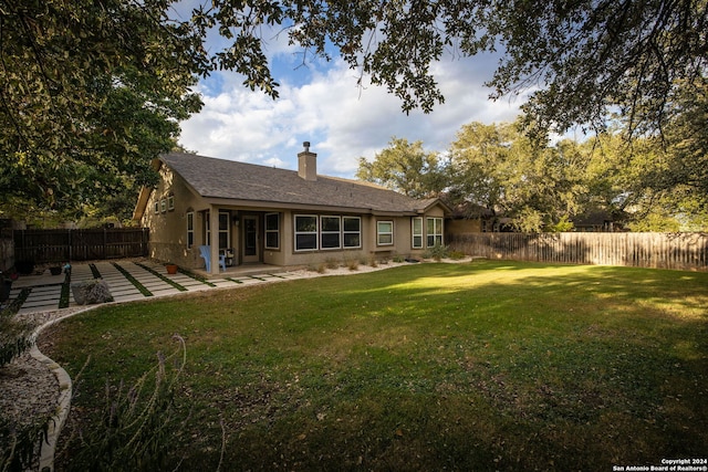 back of property featuring a patio area and a lawn