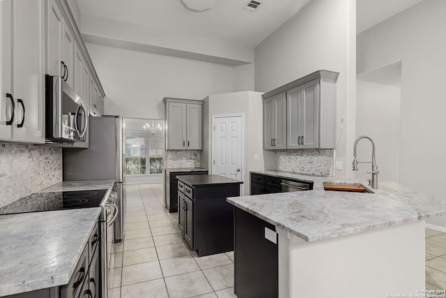 kitchen featuring light tile patterned floors, appliances with stainless steel finishes, sink, and a center island