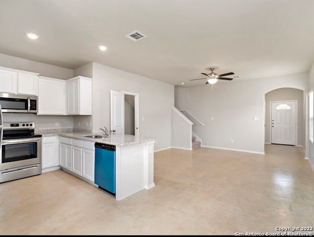 kitchen featuring stainless steel appliances, white cabinetry, sink, light stone counters, and ceiling fan