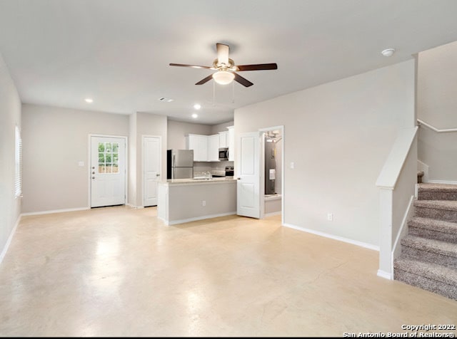 unfurnished living room with ceiling fan