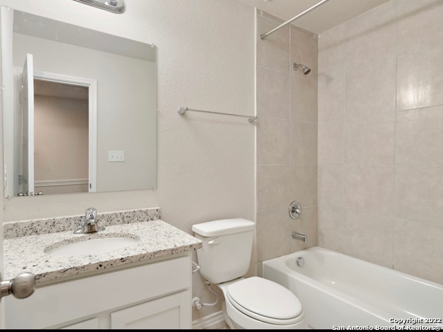 full bathroom featuring toilet, vanity, and tiled shower / bath