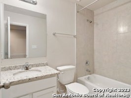 full bathroom with toilet, vanity, and tiled shower / bath