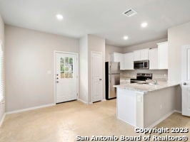 kitchen with stainless steel appliances, white cabinetry, sink, and kitchen peninsula