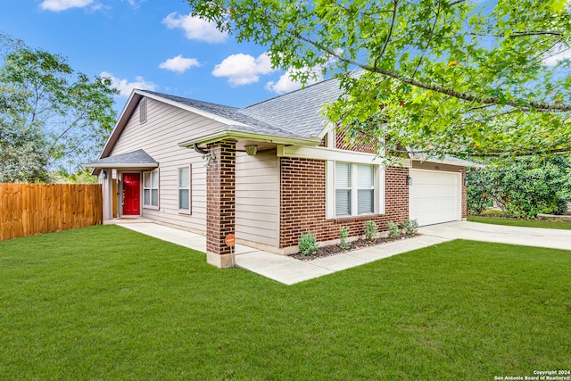 view of front of property featuring a front yard and a garage