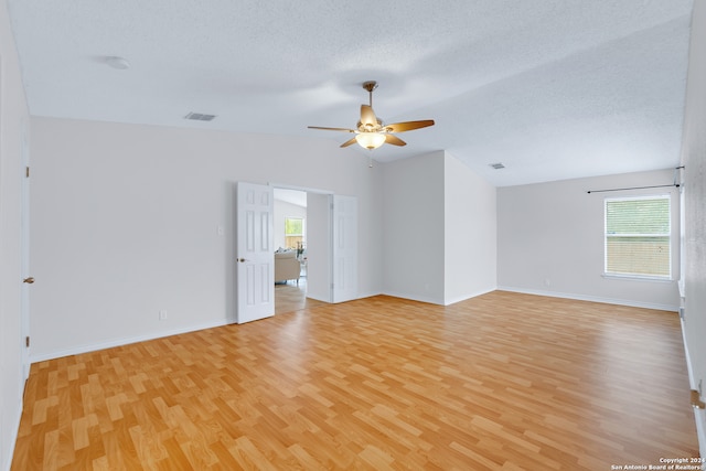 empty room featuring ceiling fan, a textured ceiling, and light hardwood / wood-style flooring