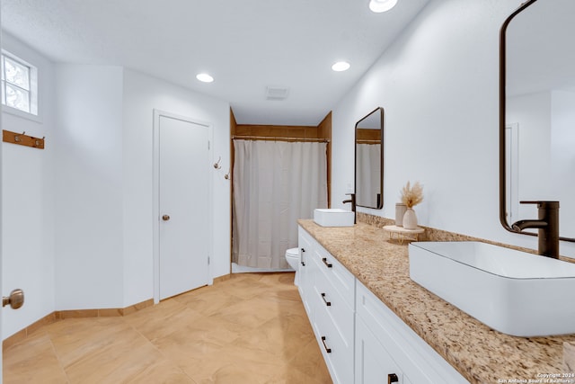 bathroom with vanity, a shower with shower curtain, and toilet