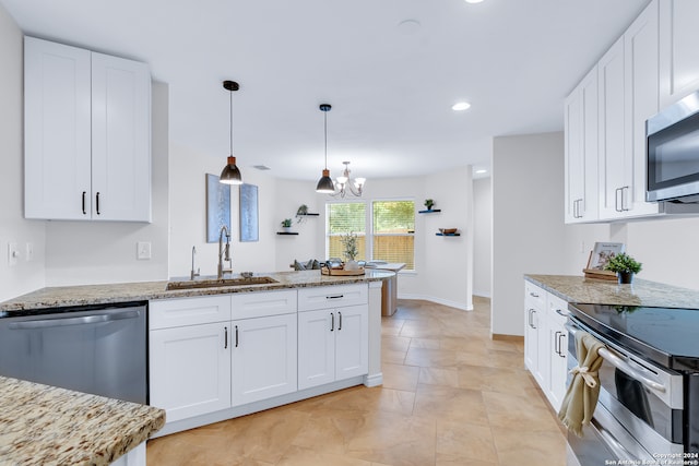 kitchen featuring hanging light fixtures, sink, appliances with stainless steel finishes, white cabinetry, and a chandelier