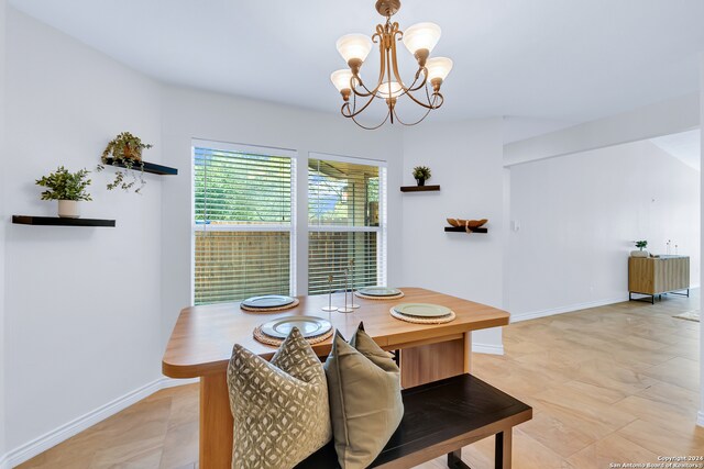 tiled dining area with a chandelier