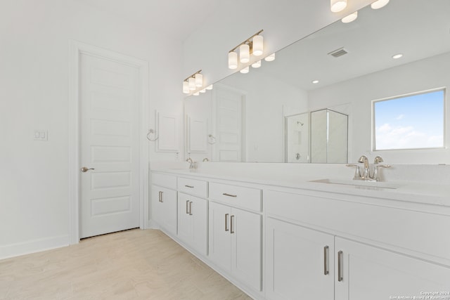 bathroom with walk in shower and vanity