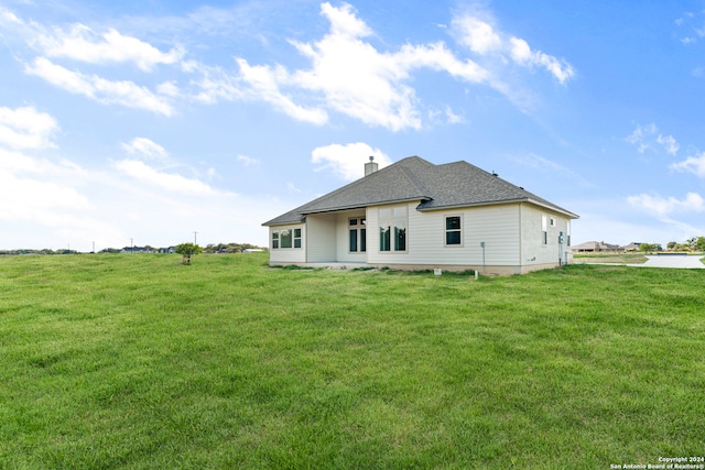 rear view of property featuring a yard