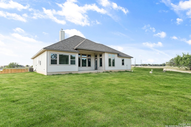 back of house featuring cooling unit and a lawn