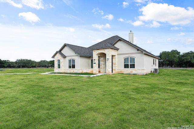 french country style house with a front yard and central AC