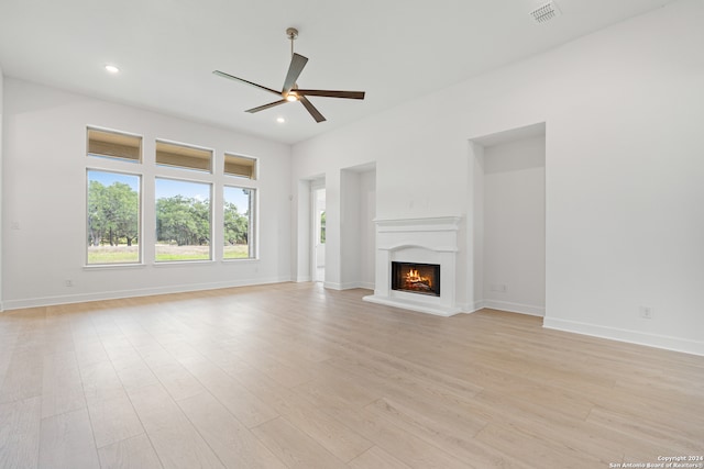 unfurnished living room with light wood-type flooring and ceiling fan