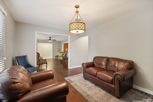 living room featuring ceiling fan and dark hardwood / wood-style flooring