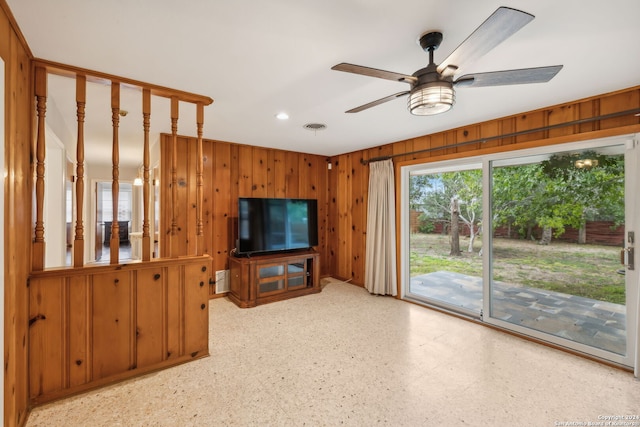 living room with wood walls and ceiling fan