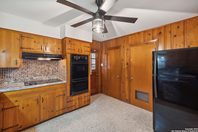 kitchen featuring black appliances, decorative backsplash, ceiling fan, and wooden walls