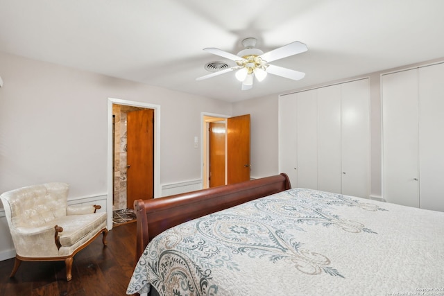 bedroom with multiple closets, ceiling fan, and dark hardwood / wood-style flooring