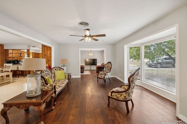 living room with ceiling fan and dark wood-type flooring