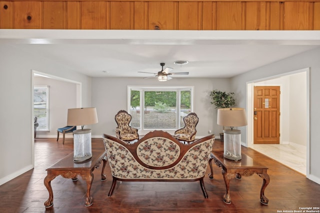 living area featuring dark hardwood / wood-style flooring and ceiling fan