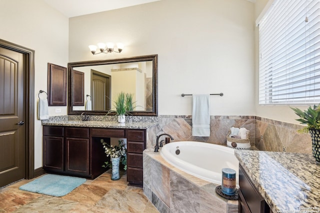 bathroom with tiled bath and vanity