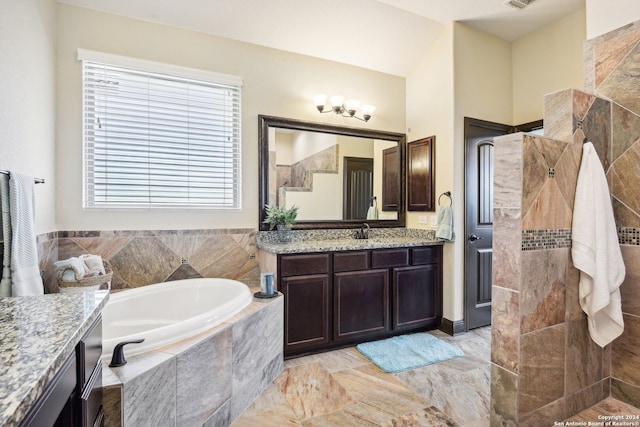 bathroom featuring tile walls, vanity, and tiled tub