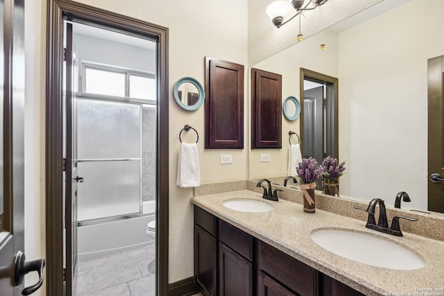 full bathroom featuring vanity, combined bath / shower with glass door, and toilet