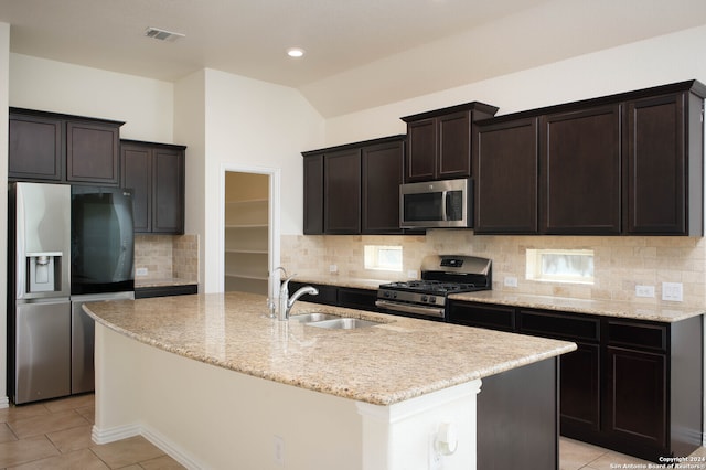 kitchen featuring stainless steel appliances, a center island with sink, sink, and vaulted ceiling