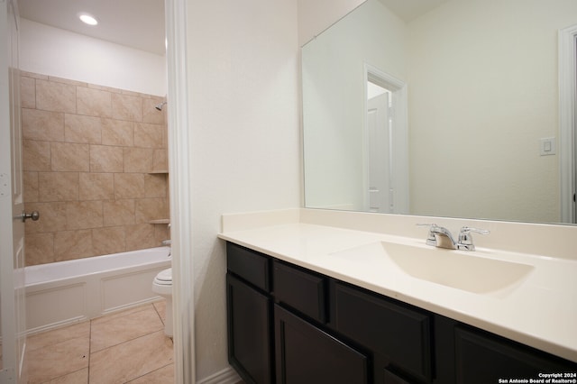 full bathroom featuring tile patterned floors, vanity, tiled shower / bath combo, and toilet