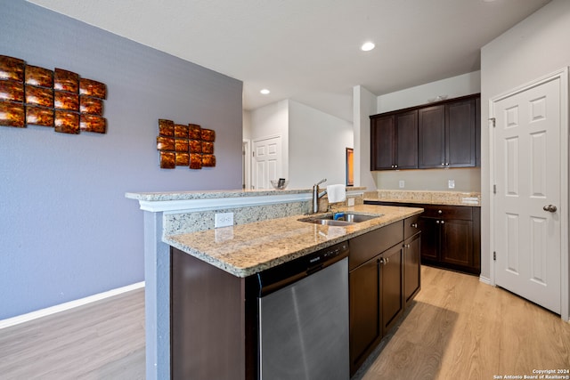 kitchen with dark brown cabinetry, sink, stainless steel dishwasher, an island with sink, and light wood-type flooring