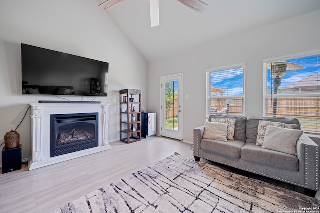 living room with ceiling fan, light hardwood / wood-style flooring, and high vaulted ceiling