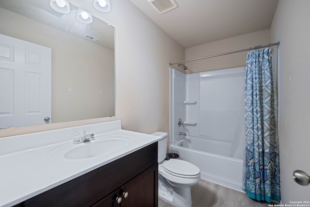 full bathroom featuring hardwood / wood-style floors, shower / tub combo with curtain, vanity, and toilet