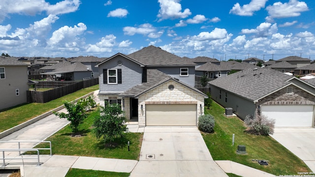 view of front facade featuring a garage, cooling unit, and a front yard