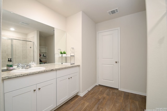 bathroom featuring hardwood / wood-style floors, vanity, and a shower with shower door