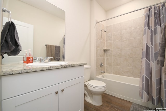 full bathroom with hardwood / wood-style flooring, vanity, shower / bathtub combination with curtain, and toilet