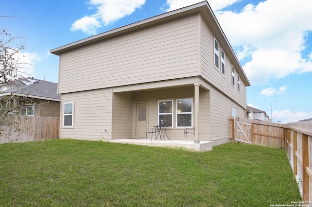 rear view of house with a lawn and a patio