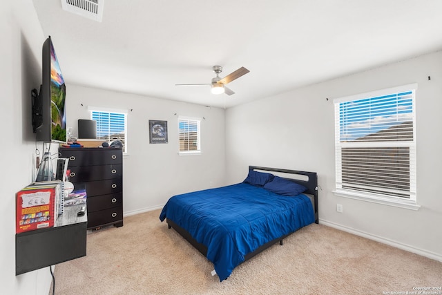 carpeted bedroom with multiple windows and ceiling fan