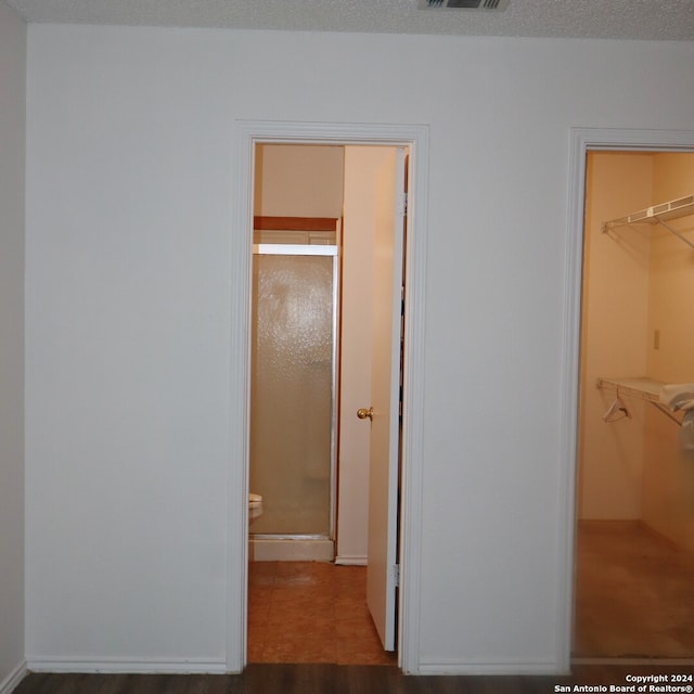 hall featuring tile patterned flooring and a textured ceiling