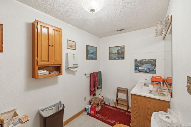 bathroom featuring a textured ceiling and vanity