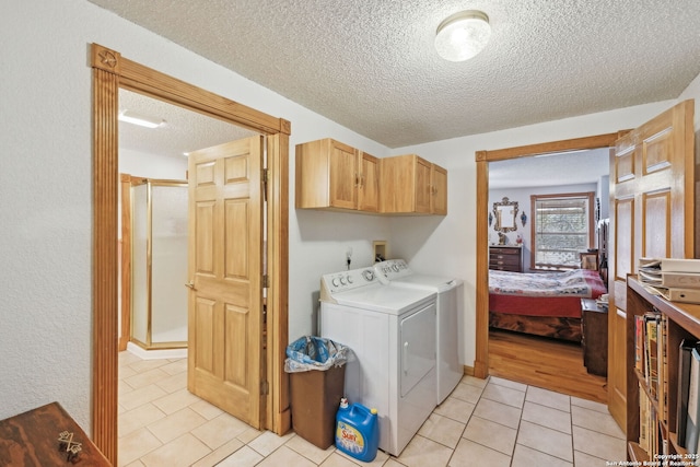 clothes washing area with cabinets, light tile patterned flooring, and independent washer and dryer