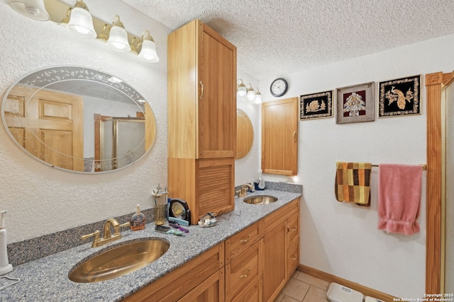 bathroom featuring a textured ceiling, a shower with shower door, tile patterned floors, and vanity