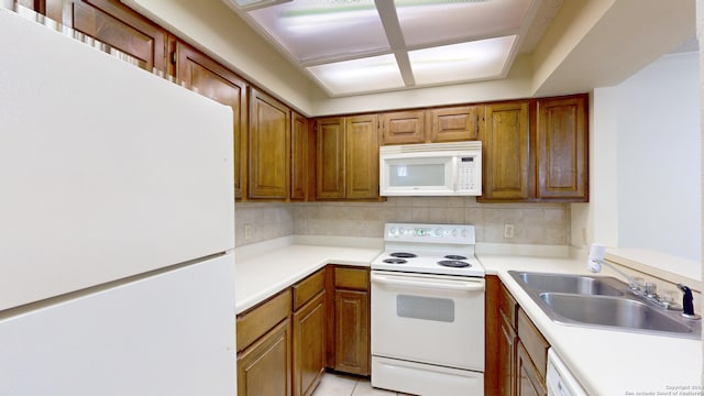 kitchen with sink, white appliances, backsplash, and light tile patterned floors