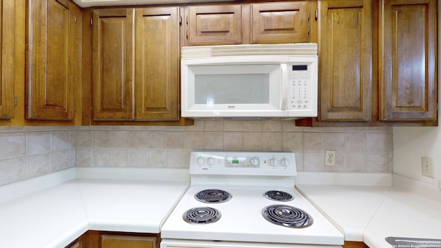 kitchen with tasteful backsplash and white appliances