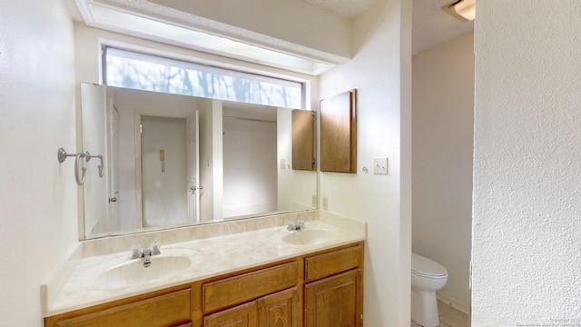 bathroom featuring a wealth of natural light, vanity, and toilet