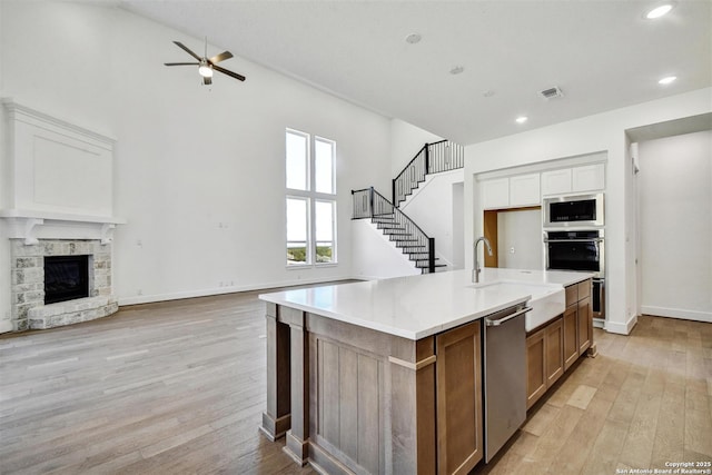 228 Dulce, Boerne, TX 78006 - kitchen featuring stainless steel appliances, open floor plan, a sink, a ceiling fan, and light wood-type flooring