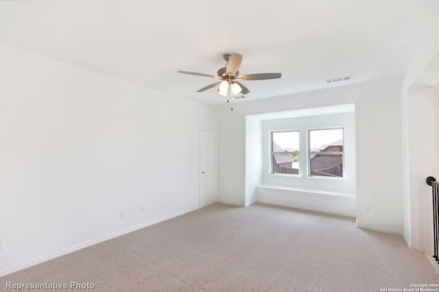 carpeted spare room with ceiling fan