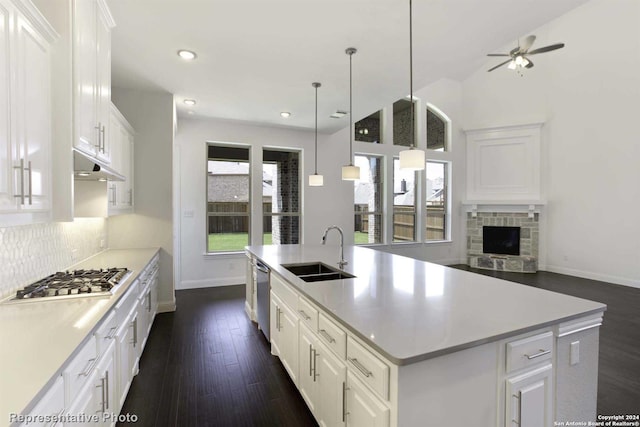 kitchen with white cabinetry, sink, dark hardwood / wood-style floors, an island with sink, and pendant lighting